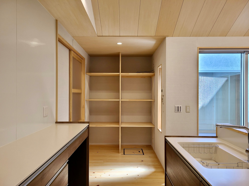 Foto de cocina lineal abierta con suelo de madera clara y casetón