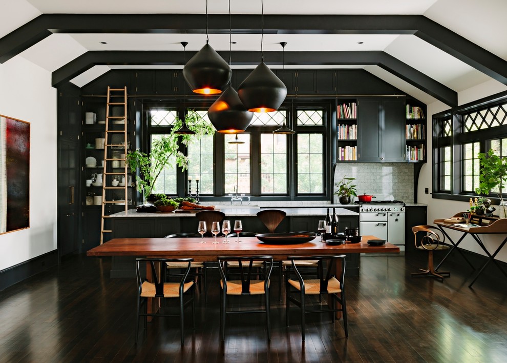 Design ideas for a transitional galley open plan kitchen in Portland with shaker cabinets, black cabinets, grey splashback, white appliances, dark hardwood floors, with island, brown floor and white benchtop.