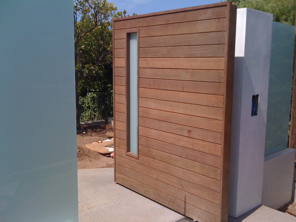 Entryway - large modern concrete floor entryway idea in Los Angeles with a dark wood front door