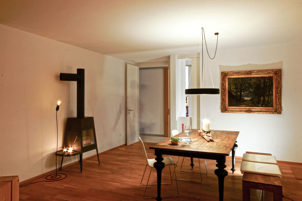 Geschlossenes, Mittelgroßes Klassisches Esszimmer mit Kaminofen und braunem Boden in Sonstige