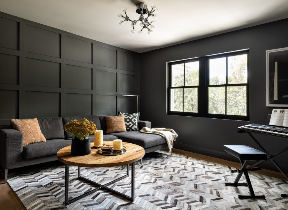 Ejemplo de sala de estar cerrada actual con paredes grises, suelo de madera clara, televisor colgado en la pared y suelo marrón