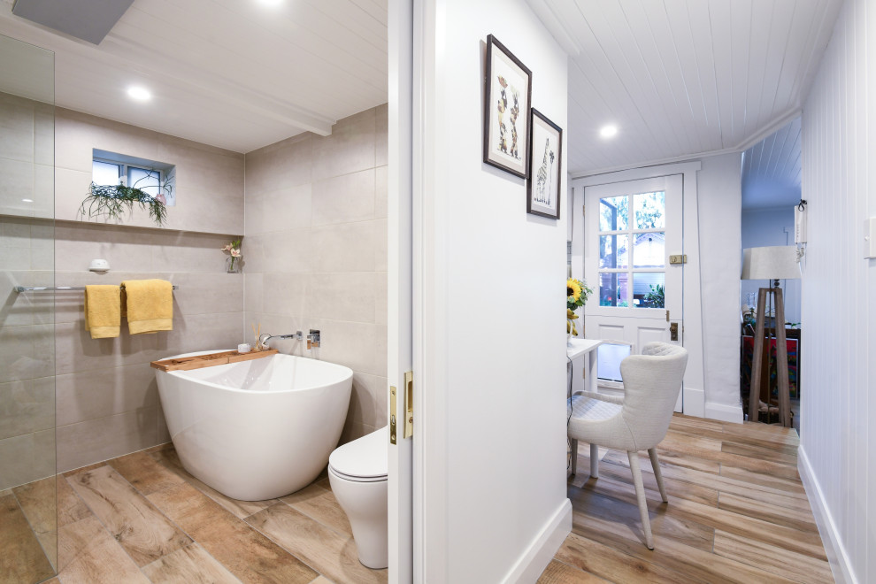 Photo of a mid-sized contemporary master wet room bathroom in Sydney with flat-panel cabinets, white cabinets, a freestanding tub, a one-piece toilet, ceramic tile, beige walls, ceramic floors, brown floor, an open shower, a single vanity and a floating vanity.