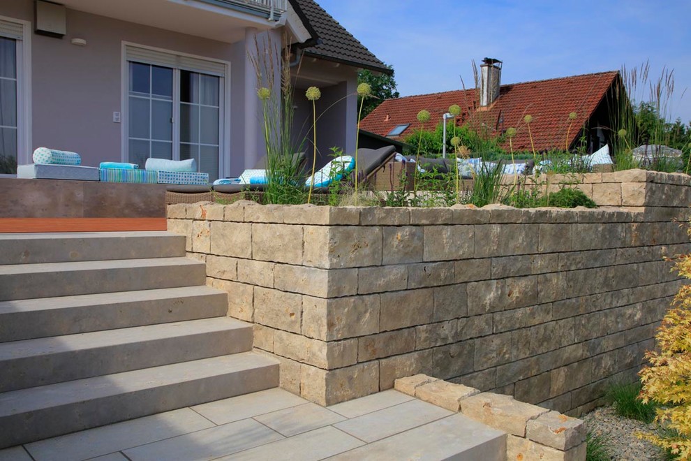 Gartenmauer im Sommer mit Gartenmauer und Natursteinplatten in Frankfurt