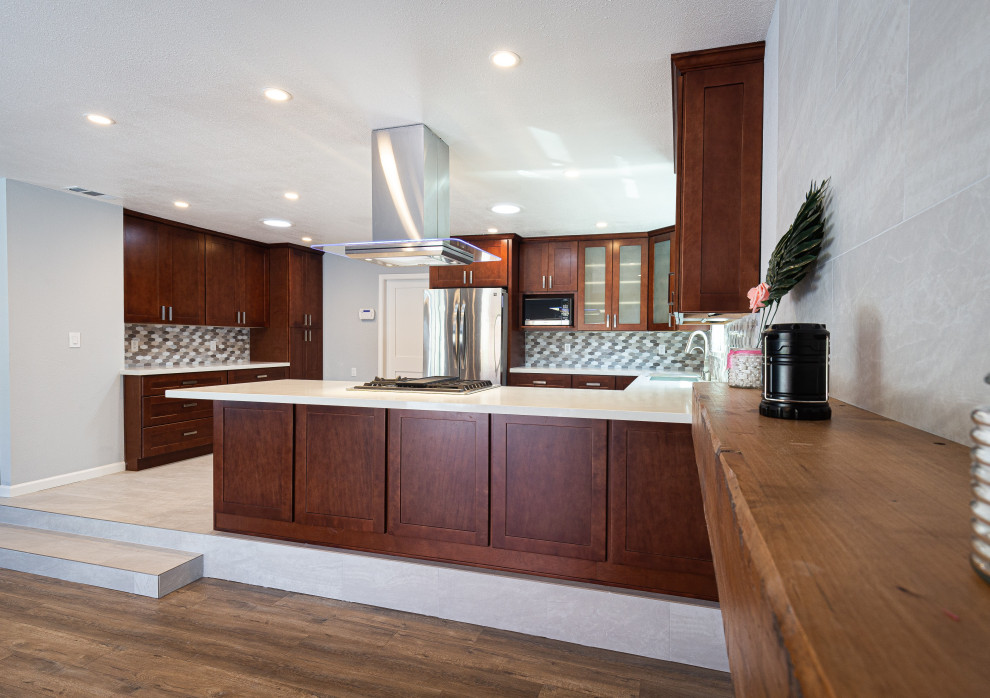 This is an example of a contemporary kitchen in San Francisco with an undermount sink, dark wood cabinets, granite benchtops, multi-coloured splashback, ceramic splashback, stainless steel appliances, ceramic floors, white floor and white benchtop.
