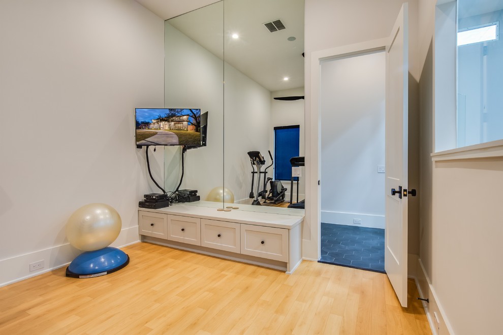 Photo of a mid-sized transitional multipurpose gym with white walls, light hardwood floors and beige floor.