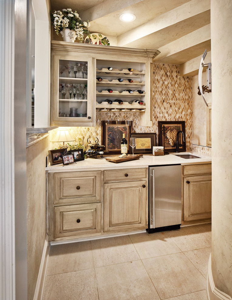 Design ideas for a traditional single-wall wet bar in Dallas with an undermount sink, beige cabinets, quartzite benchtops, beige splashback, stone tile splashback, beige floor and white benchtop.