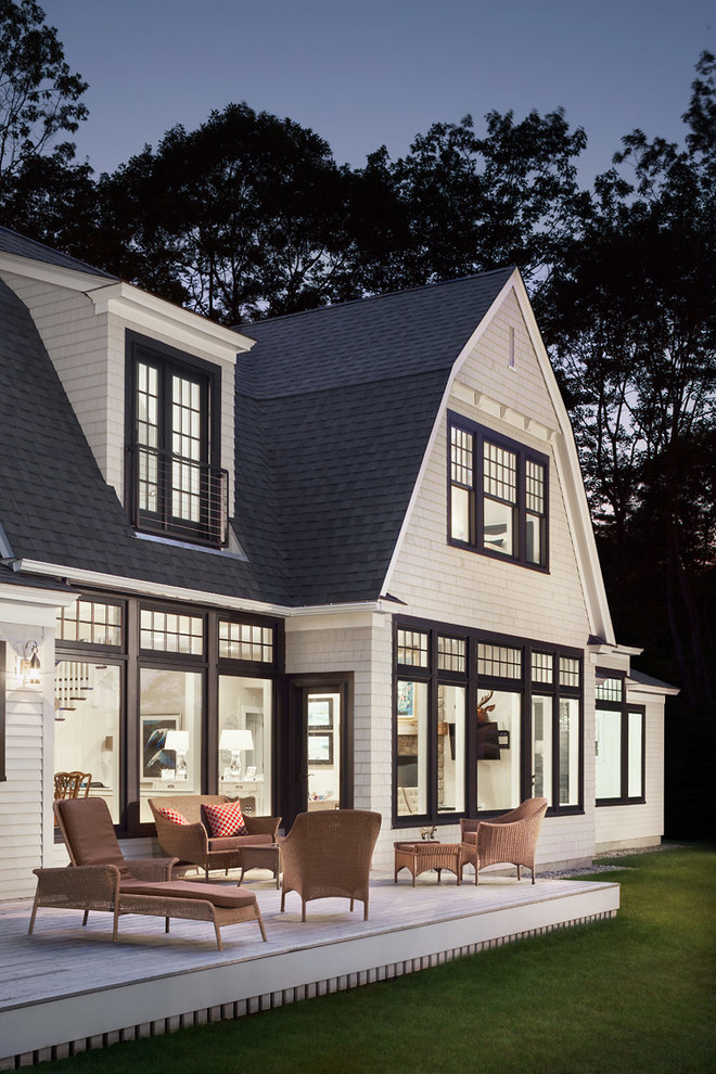 This is an example of a beach style two-storey white exterior in Portland Maine with wood siding and a gambrel roof.