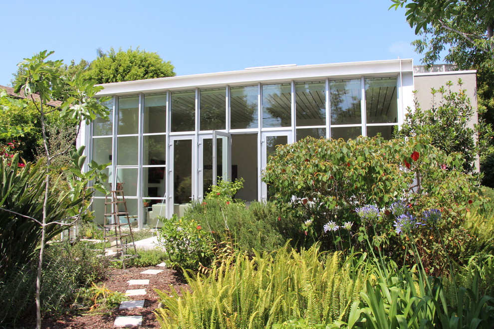 Design ideas for a contemporary one-storey glass exterior in Los Angeles.