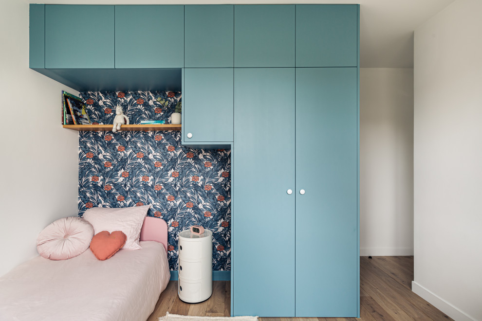 Diseño de dormitorio infantil escandinavo de tamaño medio con paredes azules y suelo de madera clara