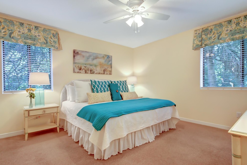 This is an example of a mid-sized beach style guest bedroom in Jacksonville with beige walls, carpet and no fireplace.