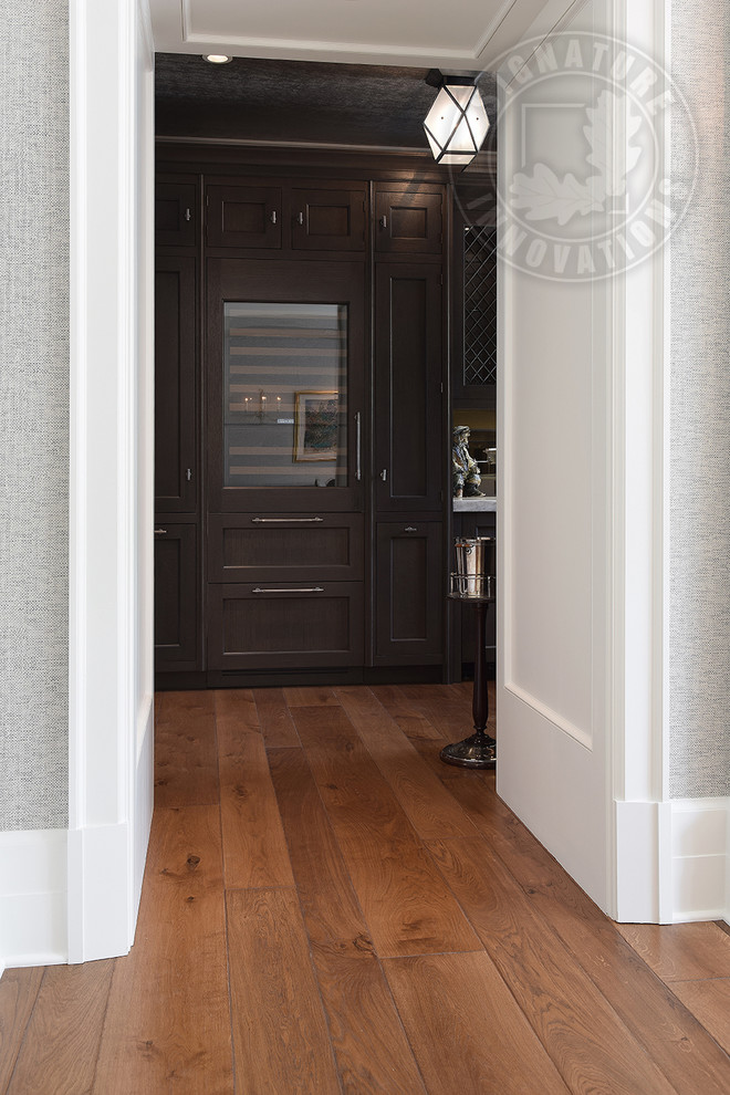 Large transitional hallway in Chicago with white walls, medium hardwood floors, brown floor and wood walls.