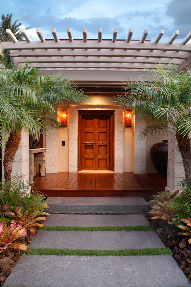 Photo of a tropical front door in Hawaii with a single front door and a dark wood front door.