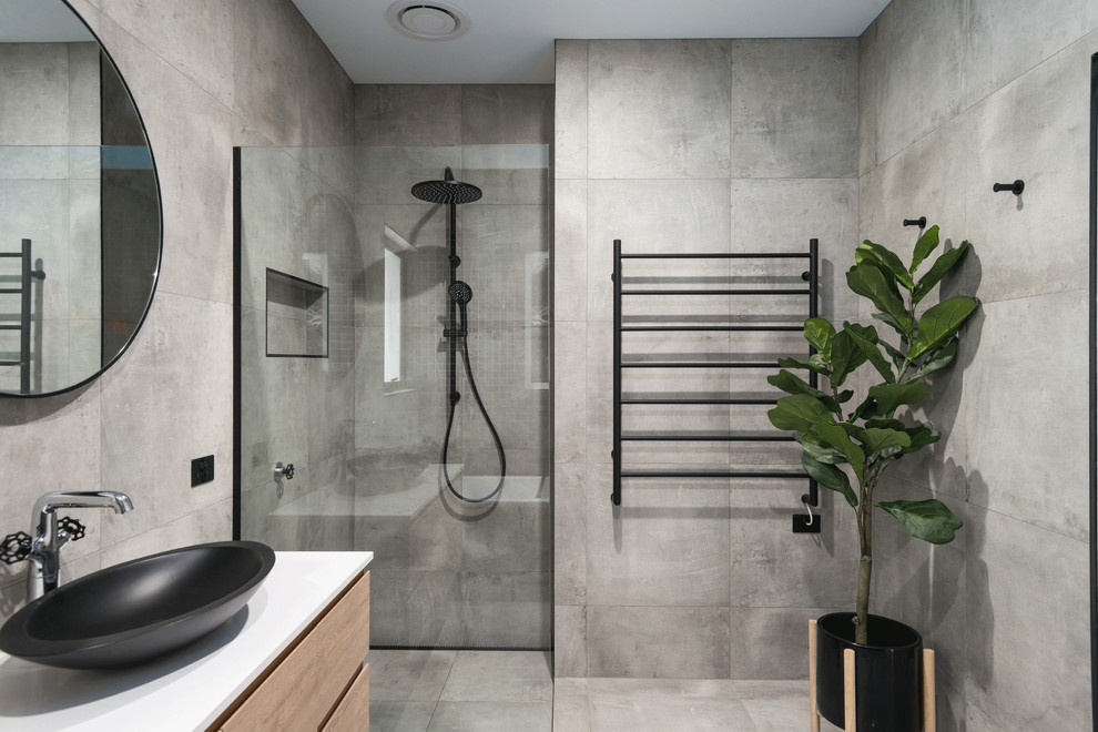 Inspiration for a modern master bathroom in Hobart with flat-panel cabinets, beige cabinets, a freestanding tub, an alcove shower, gray tile, grey walls, a vessel sink, grey floor, a hinged shower door, white benchtops and concrete floors.