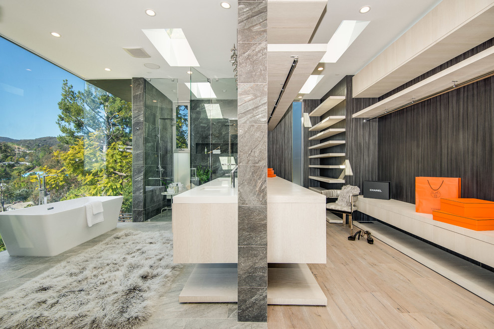 Design ideas for an expansive contemporary master bathroom in Los Angeles with louvered cabinets, light wood cabinets, a freestanding tub, a double shower, a bidet, beige tile, stone tile, white walls, an undermount sink and engineered quartz benchtops.