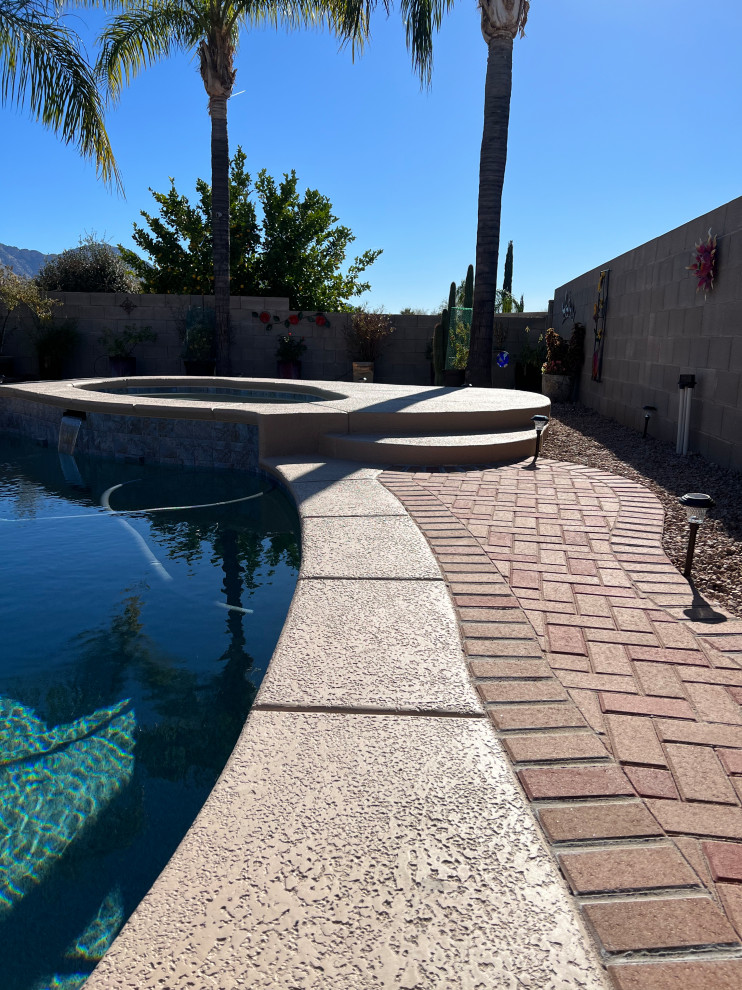 Backyard brick and round pool landscaping photo in Phoenix