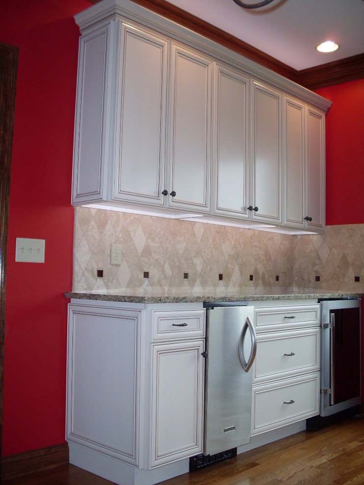 Example of a mid-sized transitional u-shaped dark wood floor open concept kitchen design in Cincinnati with an undermount sink, recessed-panel cabinets, white cabinets, granite countertops, beige backsplash, ceramic backsplash, stainless steel appliances and an island