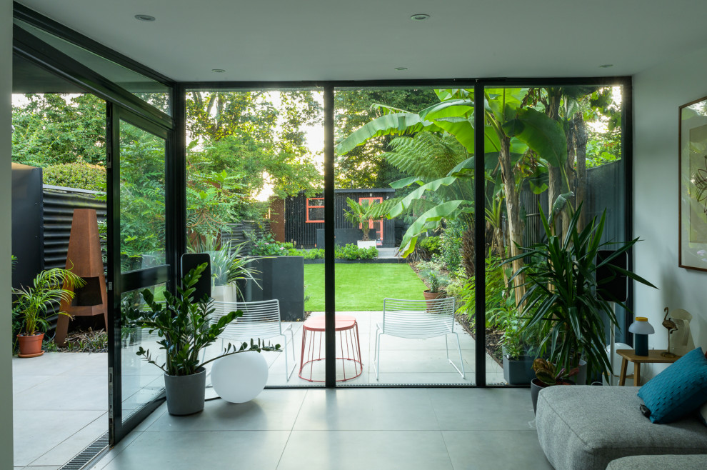 Esempio di un giardino minimal esposto a mezz'ombra di medie dimensioni e dietro casa con pavimentazioni in pietra naturale e recinzione in metallo
