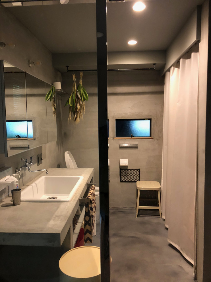 Идея дизайна: маленькая главная ванная комната со стиральной машиной в стиле модернизм с открытыми фасадами, серыми фасадами, полновстраиваемой ванной, душевой комнатой, унитазом-моноблоком, серой плиткой, серыми стенами, бетонным полом, врезной раковиной, столешницей из бетона, серым полом, открытым душем, серой столешницей, тумбой под одну раковину и встроенной тумбой для на участке и в саду