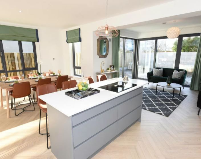 Inspiration for an expansive contemporary l-shaped open plan kitchen in Cork with a double-bowl sink, flat-panel cabinets, grey cabinets, green splashback, porcelain splashback, coloured appliances, laminate floors, an island, beige floors and white worktops.