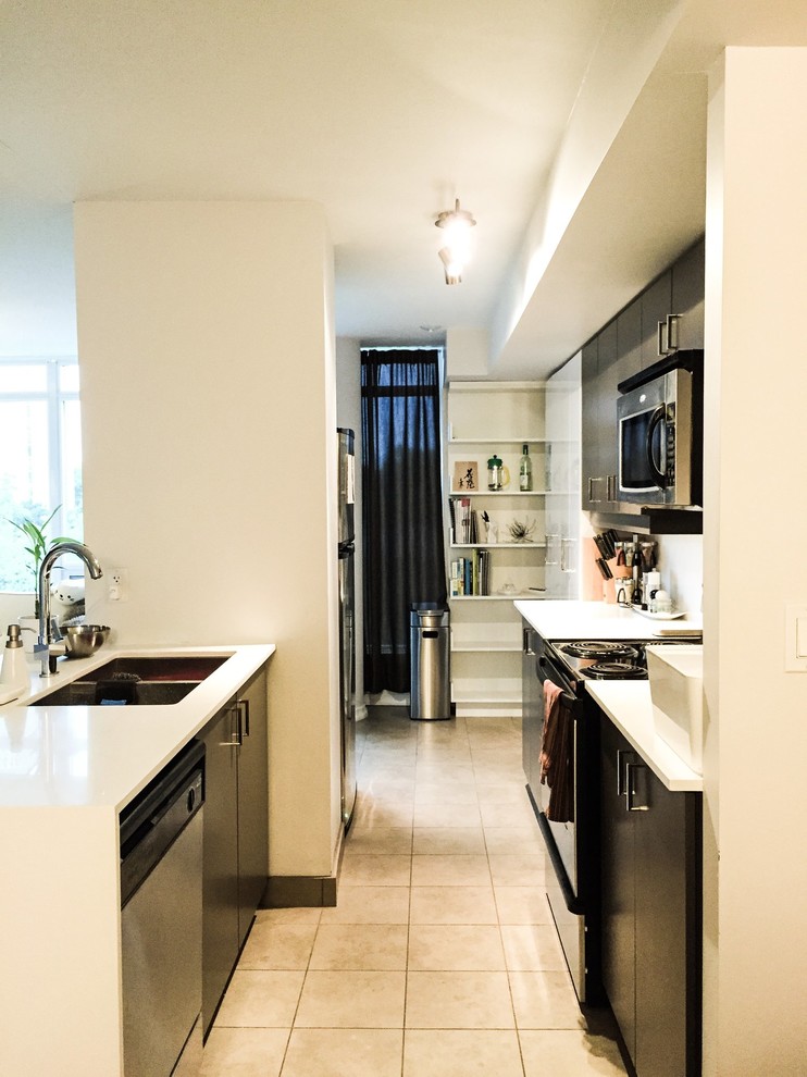 Mid-sized transitional galley ceramic tile and beige floor kitchen photo in Toronto with a double-bowl sink, flat-panel cabinets, dark wood cabinets, quartz countertops, black appliances and an island