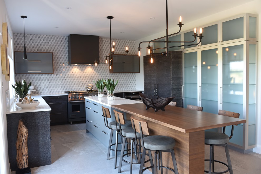 Photo of a large industrial l-shaped separate kitchen in Ottawa with granite benchtops, marble floors, with island, flat-panel cabinets, black cabinets, multi-coloured splashback, mosaic tile splashback, panelled appliances and grey floor.