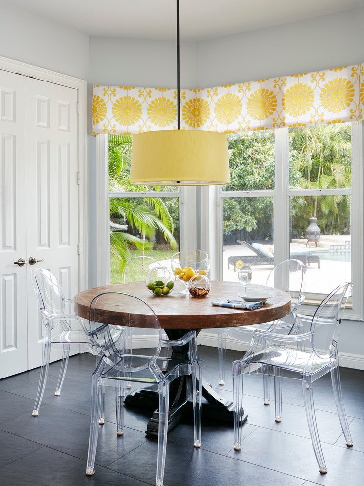 Transitional porcelain tile kitchen/dining room combo photo in Miami with a farmhouse sink, white cabinets, quartz countertops, white backsplash, glass tile backsplash, stainless steel appliances and an island