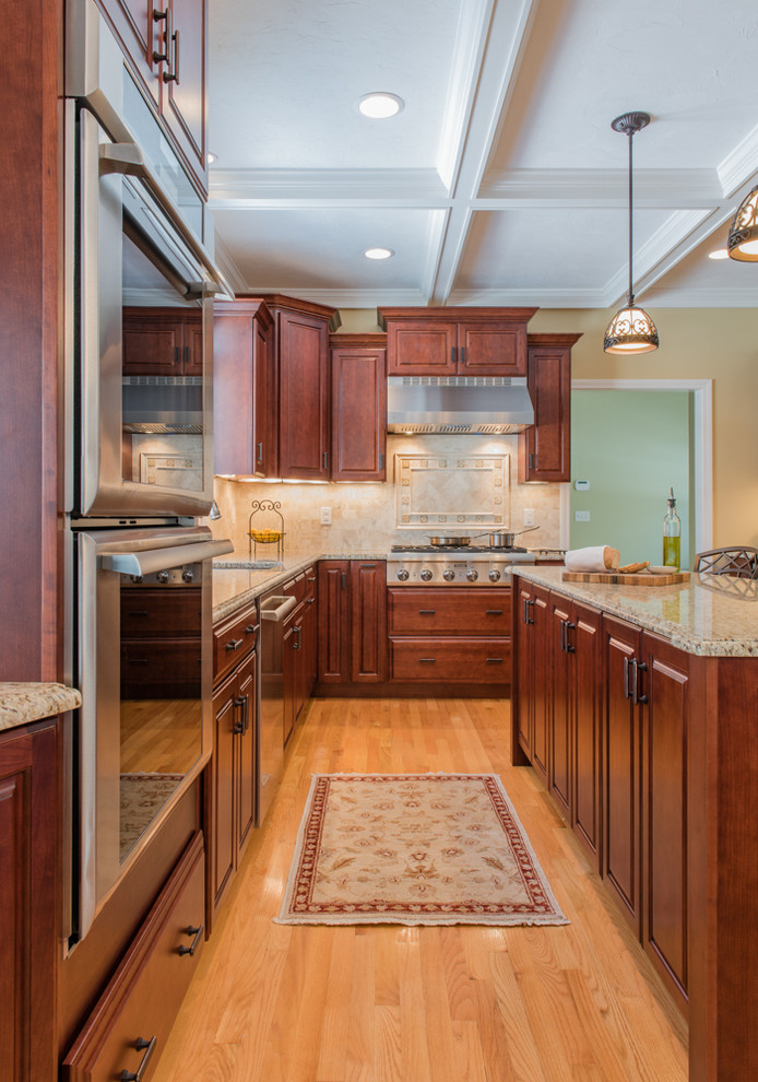 Kitchen - large transitional light wood floor kitchen idea in Boston with an undermount sink, medium tone wood cabinets, granite countertops, stone tile backsplash, stainless steel appliances and an island