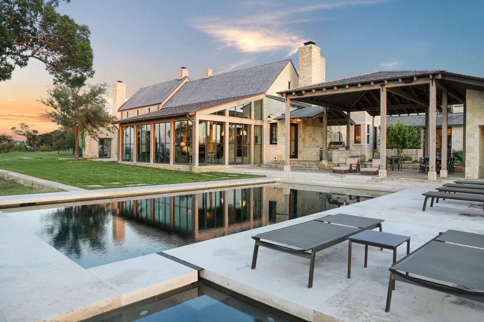 Foto di una piscina country rettangolare di medie dimensioni e dietro casa con una vasca idromassaggio e pavimentazioni in pietra naturale