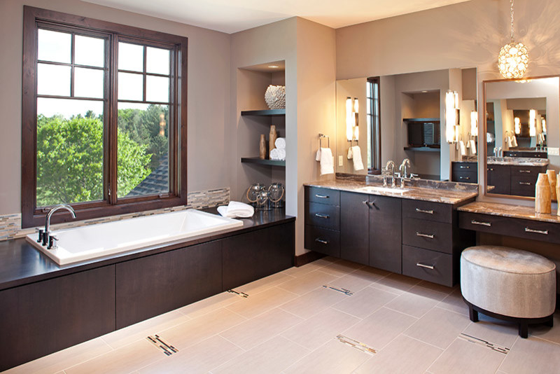 This is an example of a mid-sized transitional master bathroom in Minneapolis with flat-panel cabinets, dark wood cabinets, a drop-in tub, beige tile, matchstick tile, beige walls, porcelain floors, an undermount sink, granite benchtops and beige floor.
