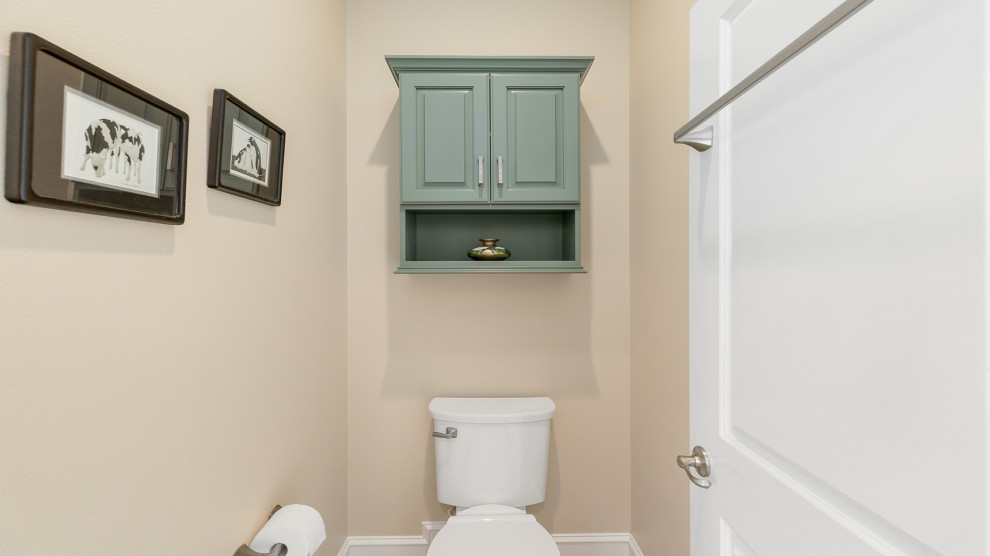 Inspiration for a mid-sized traditional master bathroom in Other with raised-panel cabinets, green cabinets, a drop-in tub, beige tile, beige walls, an undermount sink, quartzite benchtops, brown floor, a hinged shower door, beige benchtops, an enclosed toilet, a double vanity and a built-in vanity.