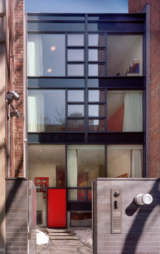 Immagine della facciata di una casa a schiera grande nera moderna a quattro piani con rivestimenti misti e tetto piano