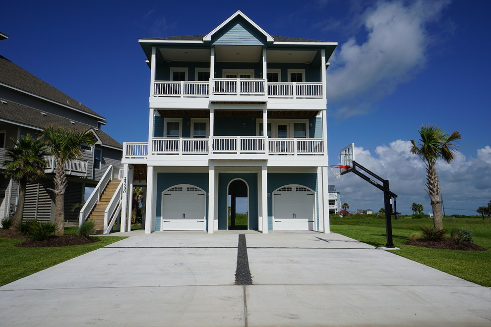 Photo of a large beach style three-storey blue exterior in Houston with concrete fiberboard siding and a hip roof.