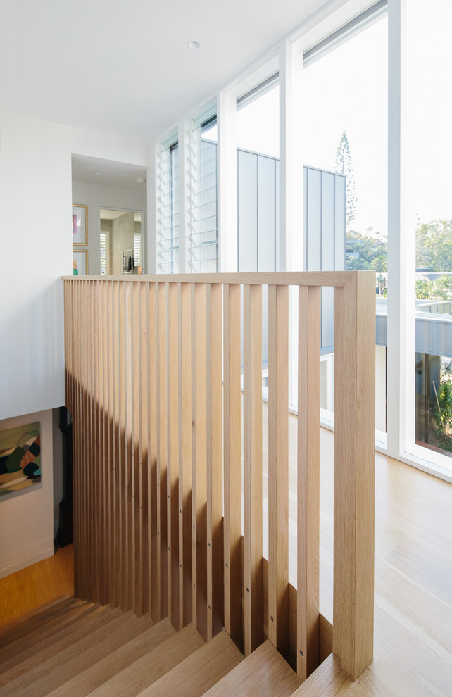 Photo of a mid-sized contemporary wood floating staircase in Other with wood risers and wood railing.