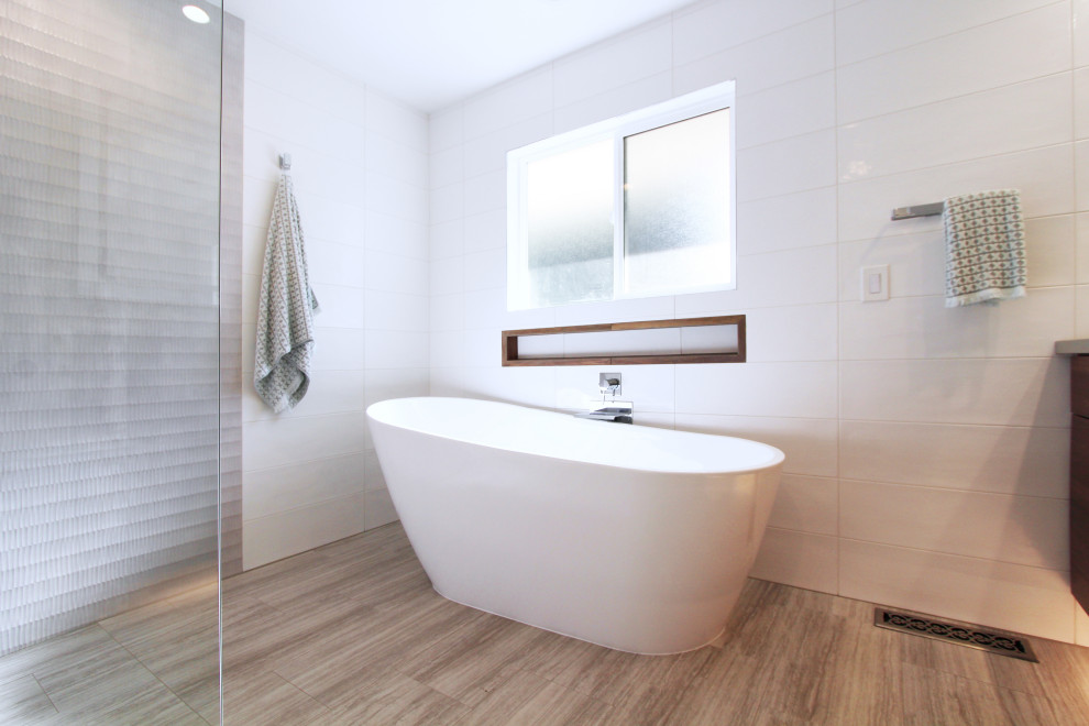 Example of a large transitional master white tile and ceramic tile porcelain tile, gray floor and double-sink freestanding bathtub design with flat-panel cabinets, dark wood cabinets, a one-piece toilet, white walls, an undermount sink, quartz countertops, gray countertops, a niche and a floating vanity