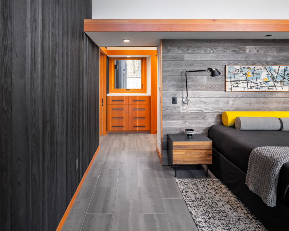 Rustikales Hauptschlafzimmer mit bunten Wänden, Porzellan-Bodenfliesen, grauem Boden und Holzwänden in Minneapolis