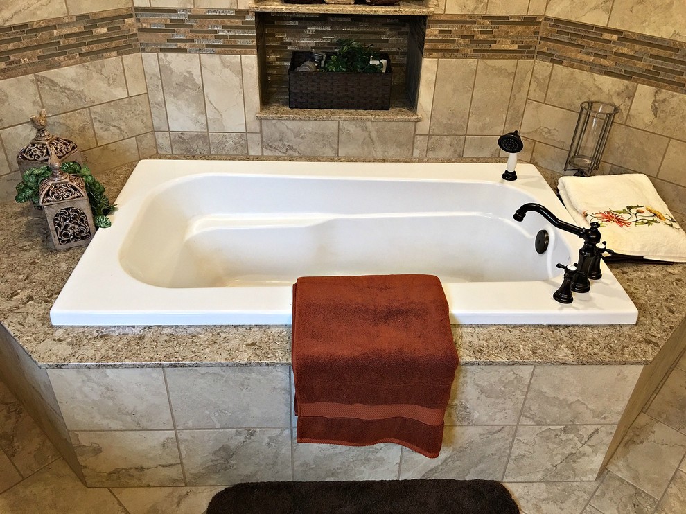 Photo of a large modern master bathroom in Other with raised-panel cabinets, dark wood cabinets, a drop-in tub, beige tile, brown tile, porcelain tile, beige walls, porcelain floors, an undermount sink and granite benchtops.