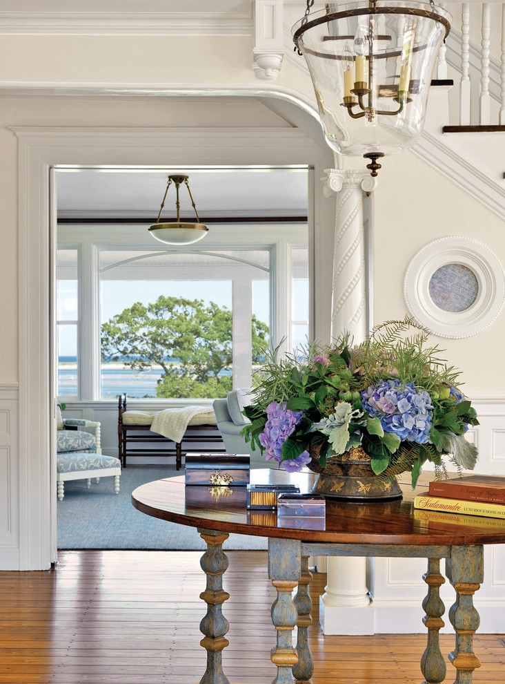 This is an example of a large beach style entry hall in Boston with white walls and medium hardwood floors.