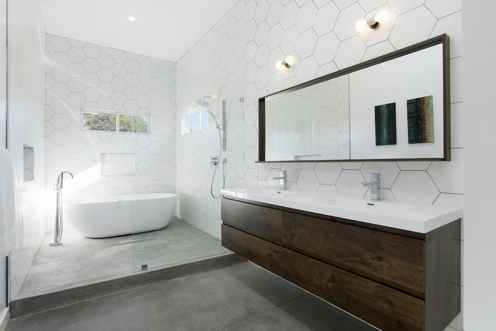 Design ideas for a contemporary master bathroom in Los Angeles with flat-panel cabinets, dark wood cabinets, a freestanding tub, an alcove shower, white tile, white walls, concrete floors, an integrated sink, grey floor, an open shower and white benchtops.