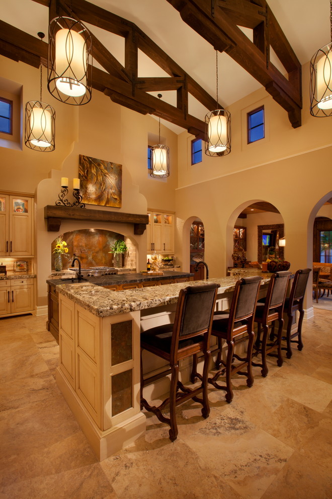 This is an example of an expansive mediterranean kitchen in Orlando with an undermount sink, raised-panel cabinets, beige cabinets, granite benchtops, stainless steel appliances, travertine floors and multiple islands.