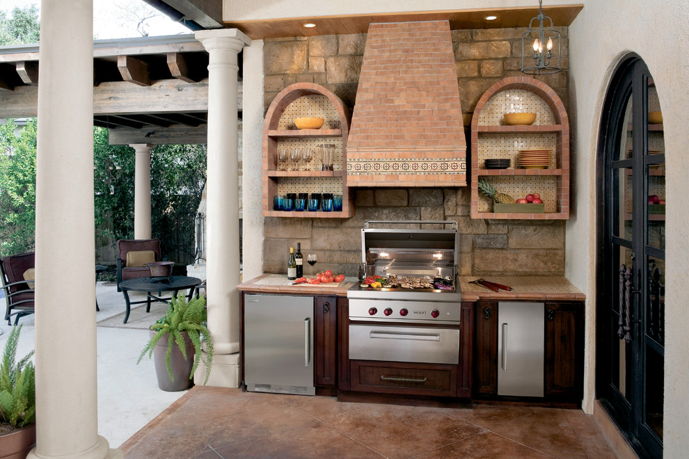 This is an example of a large traditional courtyard deck in Cleveland with an outdoor kitchen.