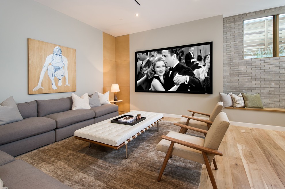 Large midcentury open concept family room in Los Angeles with grey walls and light hardwood floors.