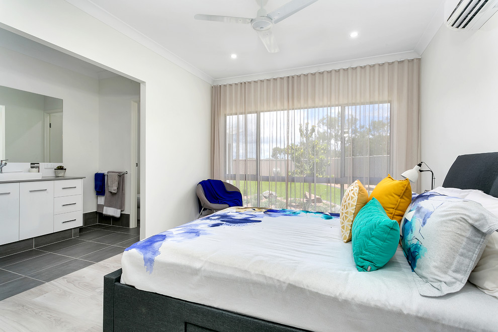 Contemporary master bedroom in Cairns with white walls and grey floor.