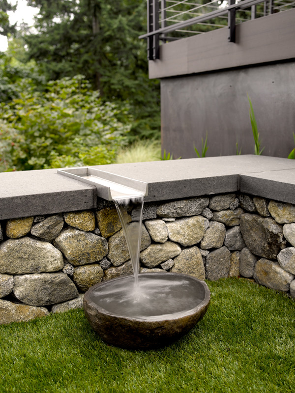 Photo of a contemporary backyard garden in Seattle with a water feature.