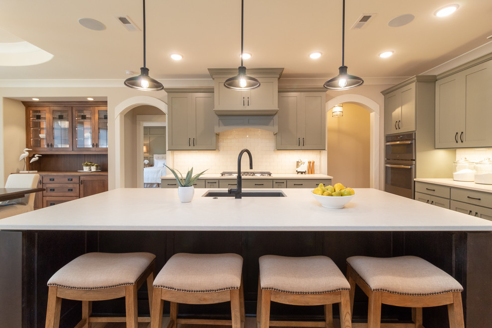 Inspiration for a mid-sized transitional l-shaped open concept kitchen remodel with an undermount sink, shaker cabinets, quartz countertops, white backsplash, subway tile backsplash, stainless steel appliances, an island and white countertops