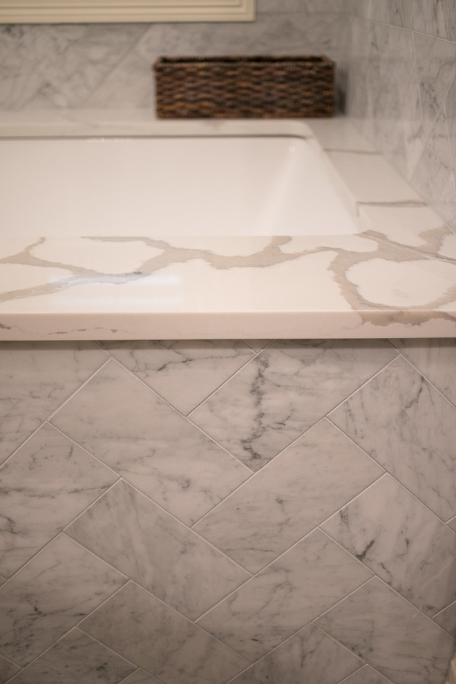 Example of a large transitional master white tile and marble tile porcelain tile and gray floor corner shower design with shaker cabinets, dark wood cabinets, an undermount tub, a one-piece toilet, brown walls, an undermount sink, quartz countertops, a hinged shower door and white countertops