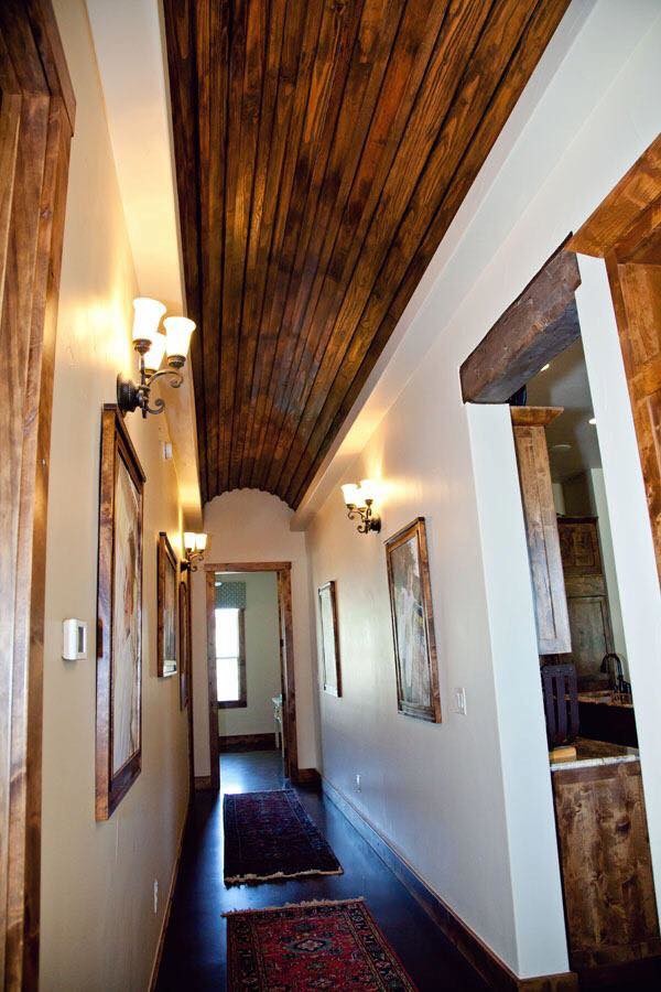 Hallway - large rustic concrete floor and brown floor hallway idea in Austin with white walls