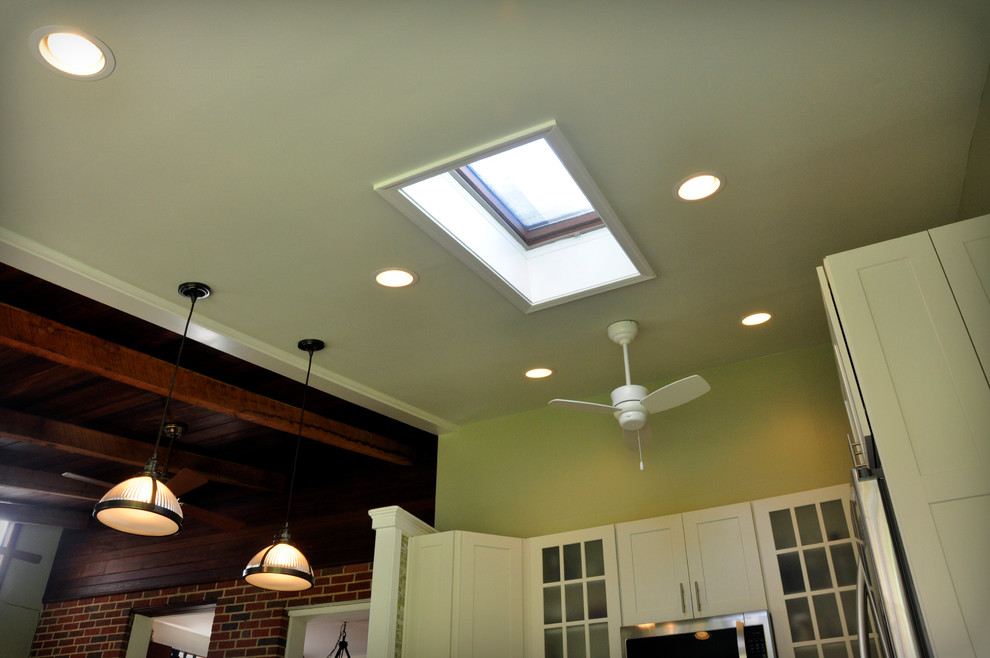 Inspiration for a mid-sized transitional u-shaped dark wood floor eat-in kitchen remodel in DC Metro with an undermount sink, shaker cabinets, white cabinets, granite countertops, yellow backsplash, glass tile backsplash, stainless steel appliances and a peninsula
