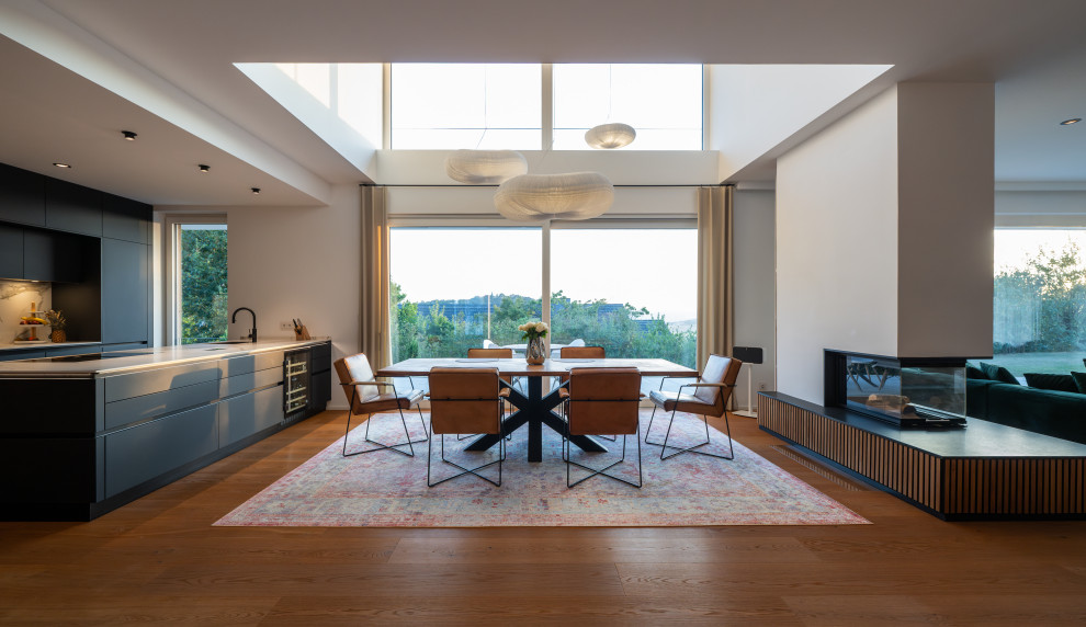 Offenes, Großes Modernes Esszimmer mit braunem Holzboden, braunem Boden und weißer Wandfarbe in Frankfurt am Main