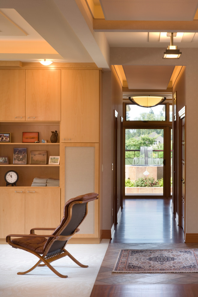 This is an example of a contemporary hallway in Portland with beige walls and dark hardwood floors.