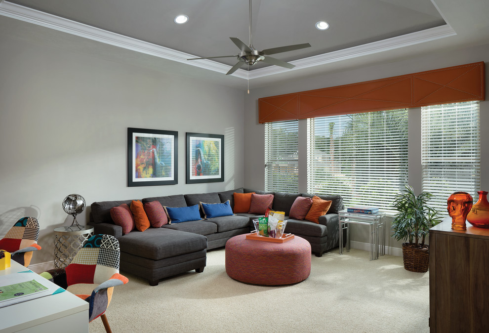 This is an example of an expansive tropical open concept family room in Tampa with grey walls, carpet and no fireplace.